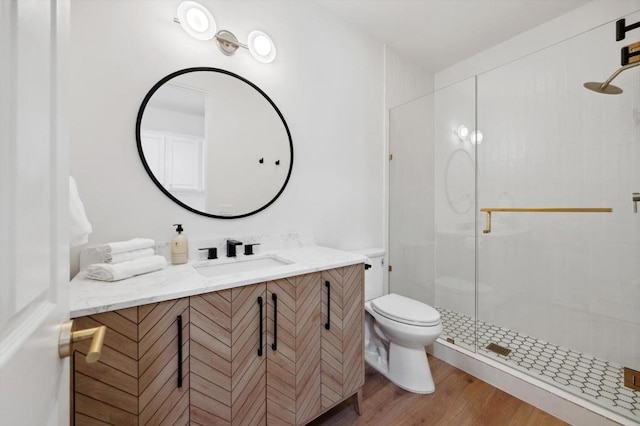 bathroom featuring toilet, a shower with door, wood-type flooring, and vanity