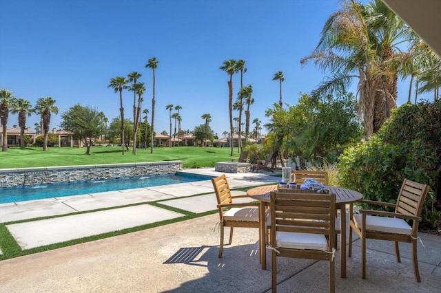 view of pool featuring a yard, pool water feature, and a patio