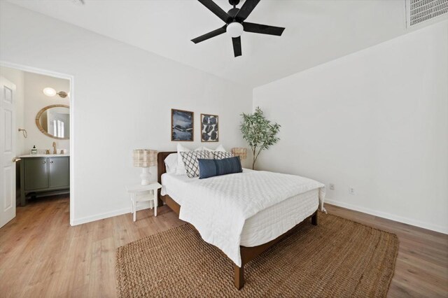 bedroom with ceiling fan, ensuite bath, light wood-type flooring, and sink