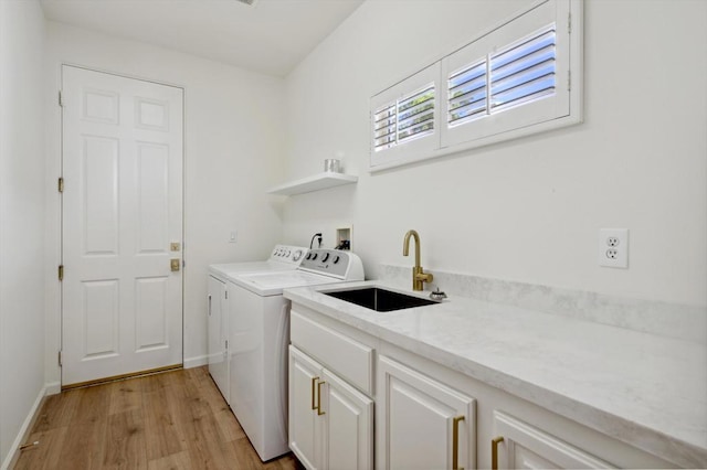 washroom with cabinets, washer and clothes dryer, sink, and light hardwood / wood-style flooring