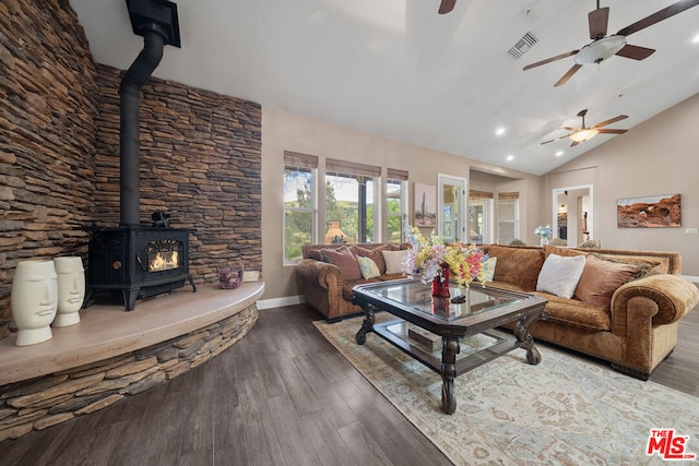 living room featuring dark wood-type flooring, lofted ceiling, and a wood stove