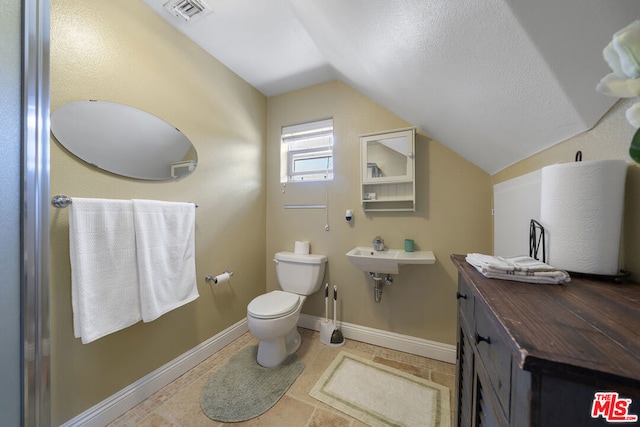 bathroom with sink, toilet, and vaulted ceiling