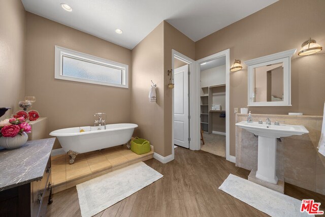 bathroom featuring a tub, sink, and hardwood / wood-style flooring