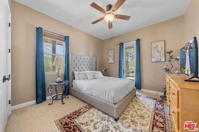 carpeted bedroom with ceiling fan and multiple windows