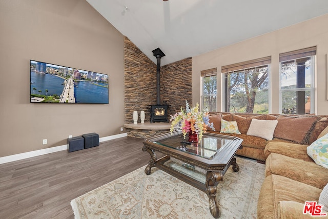 living room featuring high vaulted ceiling, wood-type flooring, and a wood stove