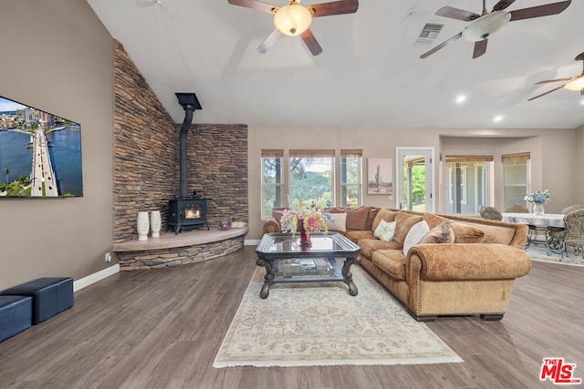 living room featuring ceiling fan, a wood stove, and hardwood / wood-style floors