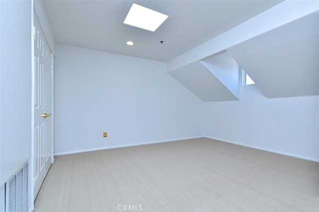 bonus room featuring vaulted ceiling with skylight and light colored carpet