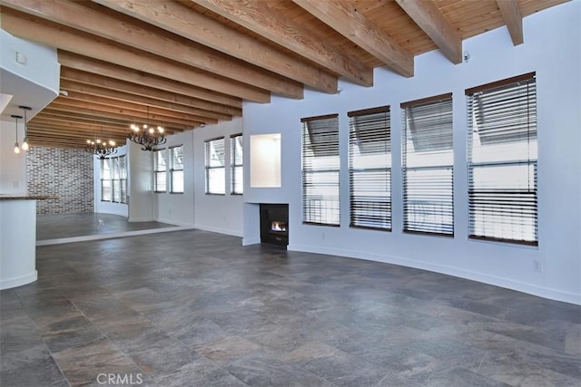 unfurnished living room featuring wooden ceiling, a chandelier, and beamed ceiling