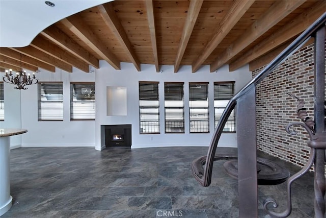 unfurnished living room with wooden ceiling, a chandelier, and beam ceiling