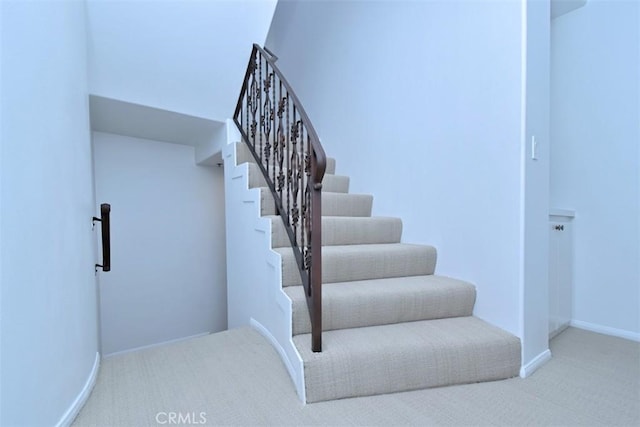 stairs featuring carpet flooring