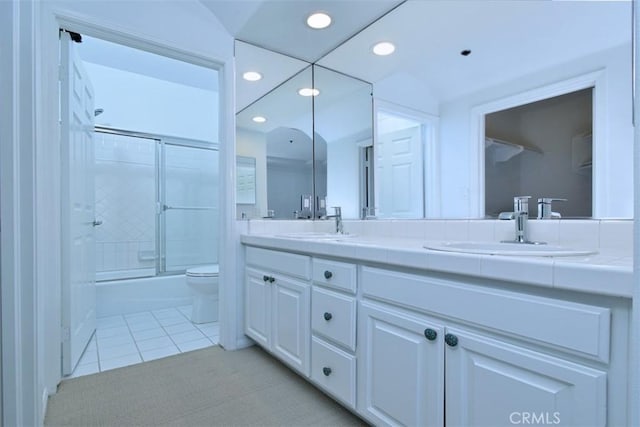 full bathroom with toilet, bath / shower combo with glass door, tile patterned flooring, and vanity