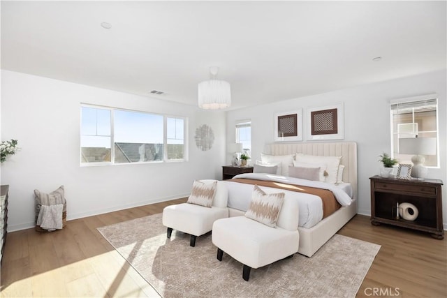 bedroom with wood-type flooring and a chandelier