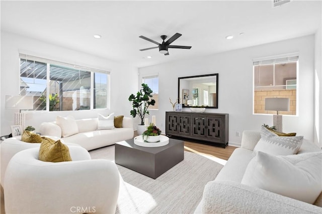 living room featuring ceiling fan and light hardwood / wood-style flooring