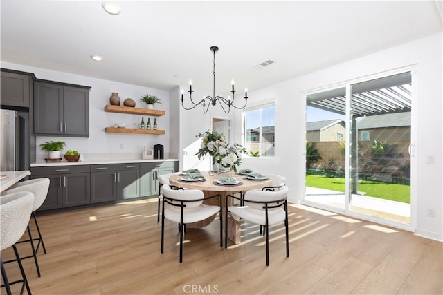 dining area featuring light hardwood / wood-style flooring and a notable chandelier