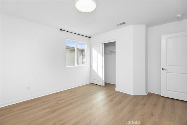 unfurnished bedroom with a closet and light wood-type flooring