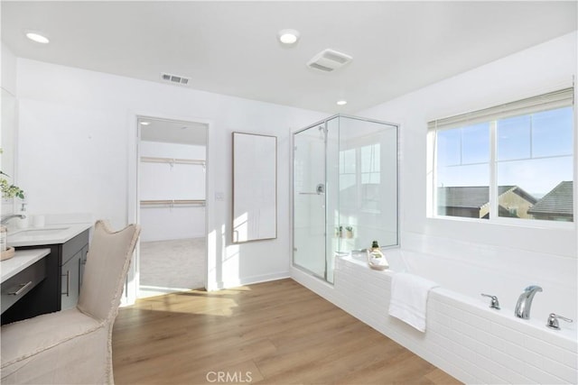 bathroom with separate shower and tub, vanity, and hardwood / wood-style floors