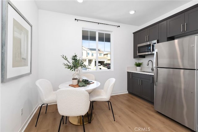 dining area with sink and light hardwood / wood-style flooring