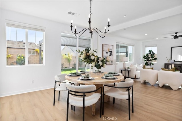 dining room with light wood-type flooring, beam ceiling, and ceiling fan with notable chandelier