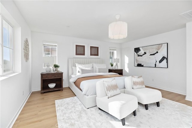 bedroom with hardwood / wood-style flooring and multiple windows