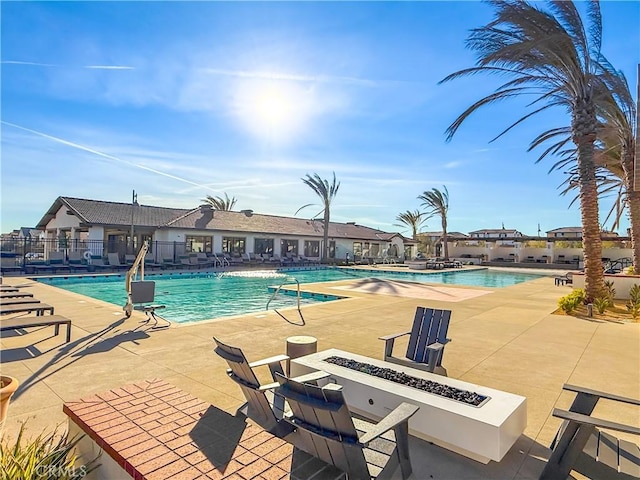 view of swimming pool with a patio and a fire pit