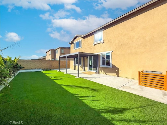 rear view of house featuring a patio area and a yard