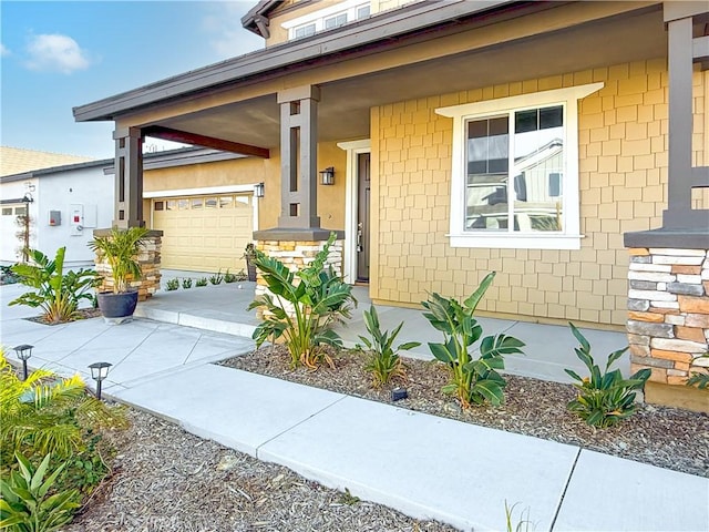 view of exterior entry featuring a garage and covered porch