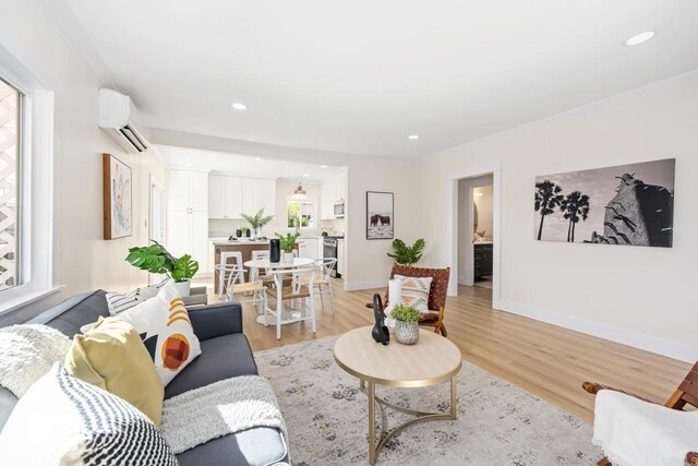 living room with crown molding, a wall mounted air conditioner, and light hardwood / wood-style floors