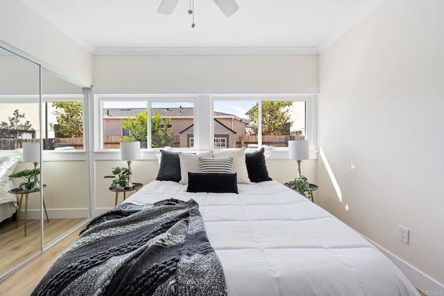 bedroom with ceiling fan, ornamental molding, and wood-type flooring