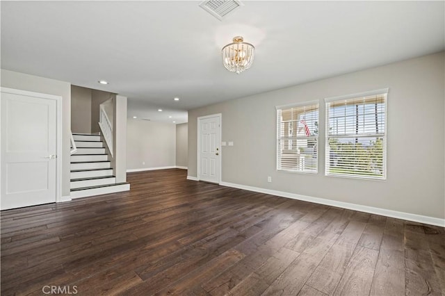 unfurnished living room with dark hardwood / wood-style flooring and a chandelier