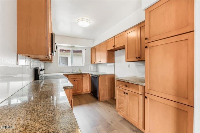 kitchen with dishwasher, stone counters, light hardwood / wood-style floors, sink, and range