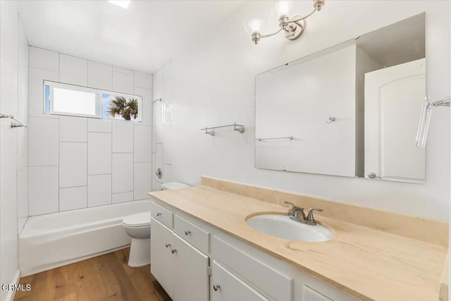 full bathroom with wood-type flooring, toilet, vanity, and tiled shower / bath