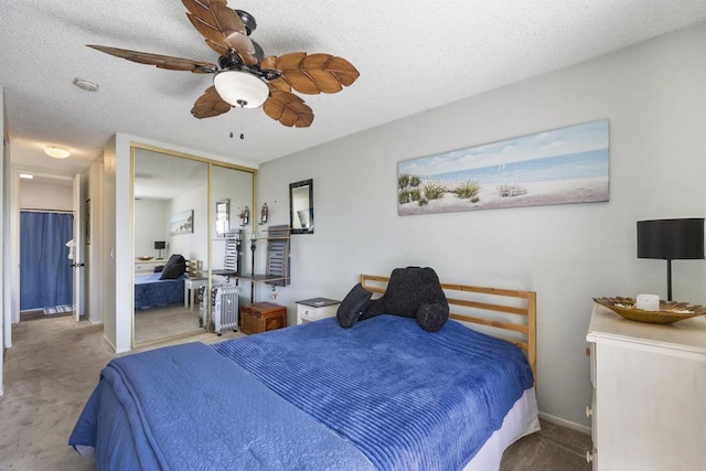 bedroom featuring ceiling fan, light colored carpet, a closet, and a textured ceiling