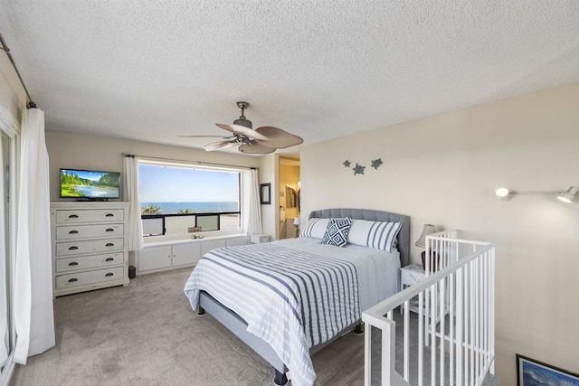 carpeted bedroom featuring a textured ceiling and ceiling fan