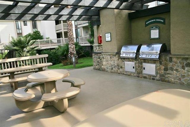 view of patio featuring exterior kitchen, a grill, and a pergola