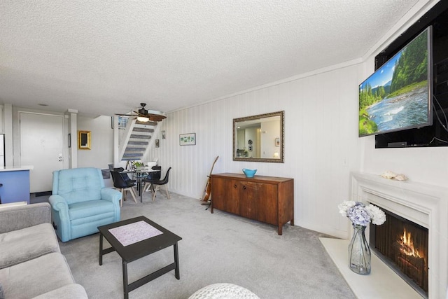 living room featuring ceiling fan, light carpet, and a textured ceiling