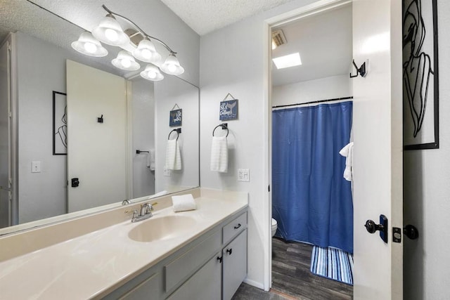 bathroom with a textured ceiling, vanity, a shower with curtain, toilet, and hardwood / wood-style flooring