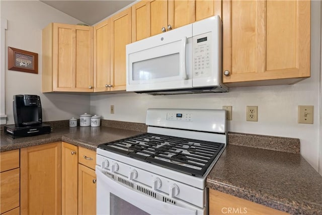 kitchen with white appliances, light brown cabinets, and vaulted ceiling