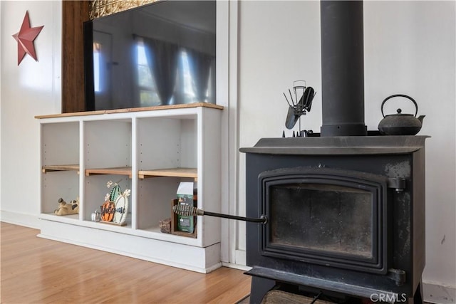 interior details featuring a wood stove and hardwood / wood-style flooring