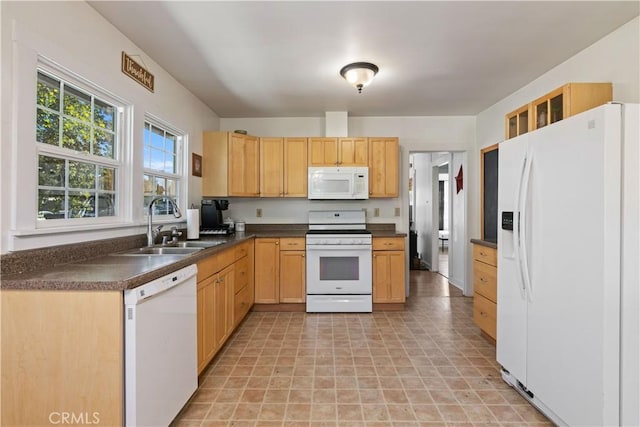 kitchen with light brown cabinetry, sink, and white appliances