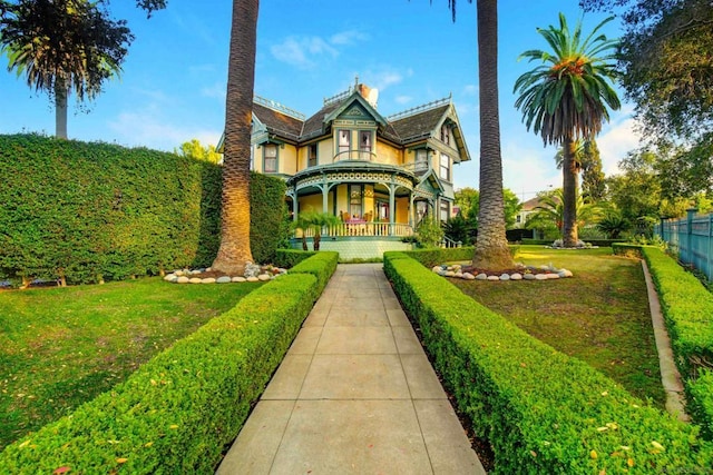 victorian home with a front lawn and a porch