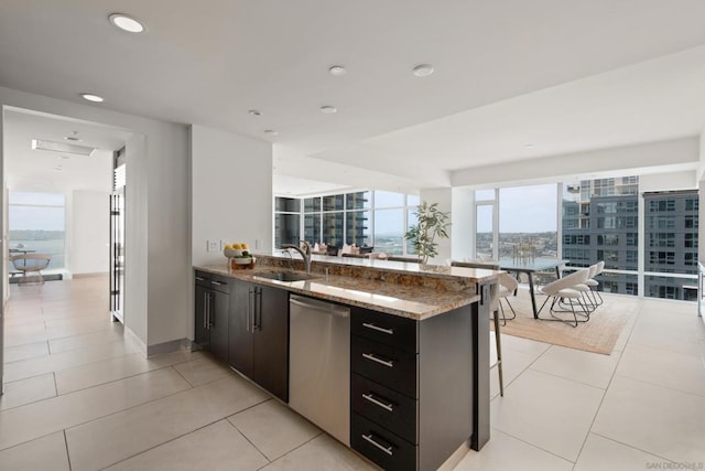 kitchen with dishwasher, stone counters, kitchen peninsula, sink, and a breakfast bar area