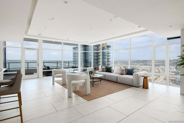 tiled living room featuring a wall of windows and a water view