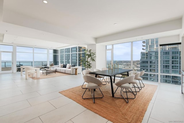 dining space featuring a water view, expansive windows, and light tile patterned floors