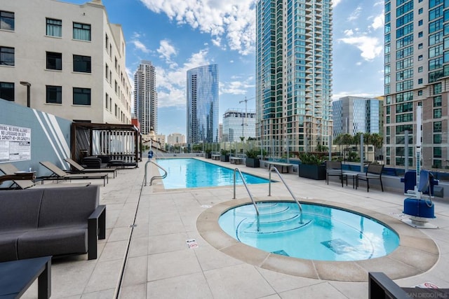 view of swimming pool featuring a patio area and a hot tub