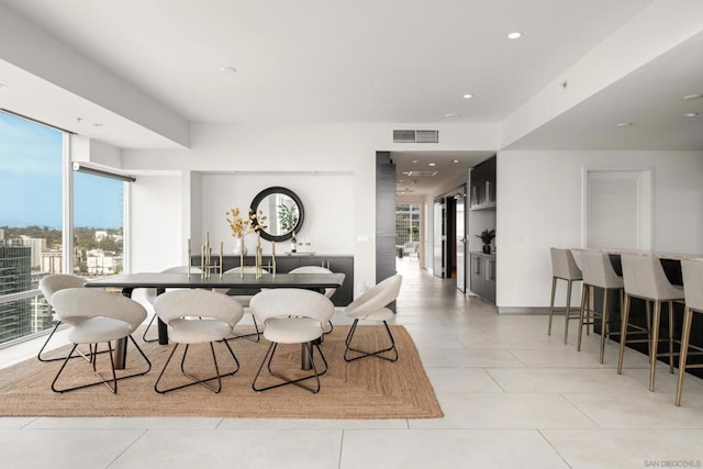 dining area featuring light tile patterned floors and floor to ceiling windows