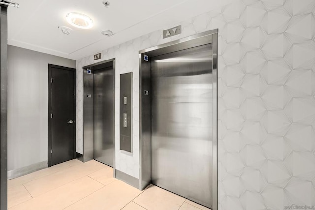 hallway featuring light tile patterned floors and elevator