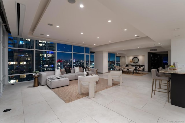 interior space featuring light tile patterned floors, floor to ceiling windows, and a tray ceiling