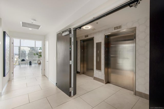 corridor featuring light tile patterned floors and elevator