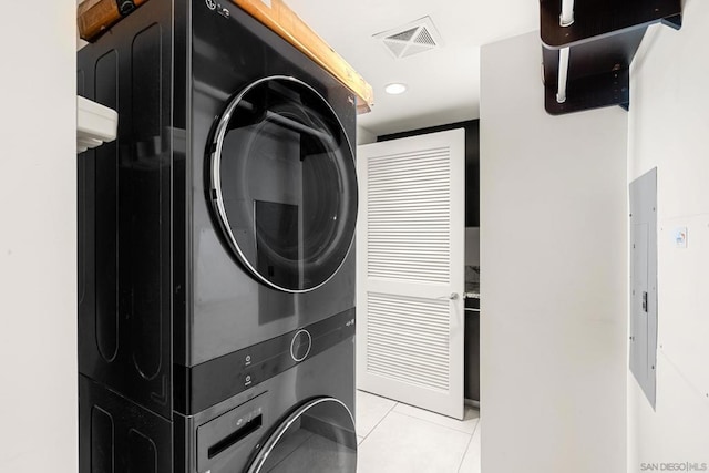 washroom with light tile patterned floors and stacked washer and clothes dryer