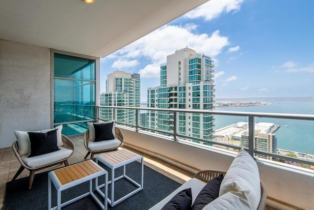 balcony with an outdoor living space and a water view